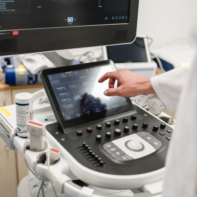 Blick über die Schulter eines Arztes, der an einem Gerät arbeitet