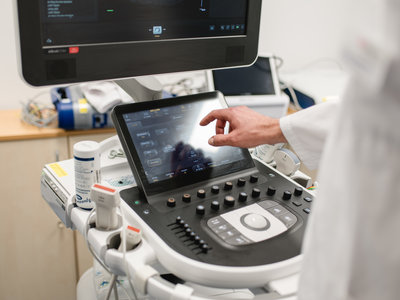 Blick über die Schulter eines Arztes, der an einem Gerät arbeitet